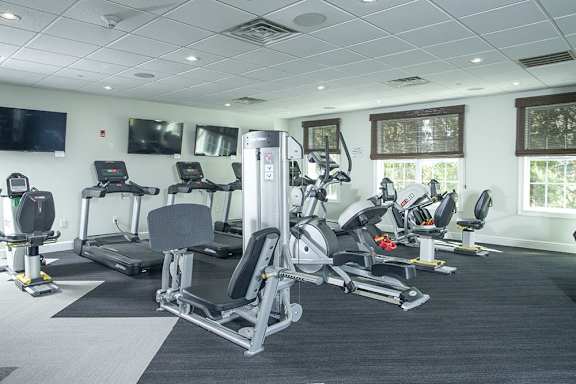 A gym with treadmills, elliptical machines, and other cardio equipment.