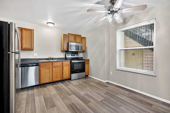 A kitchen with wooden cabinets and a black refrigerator.