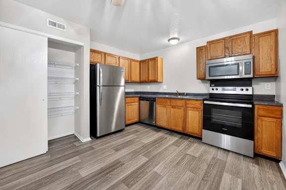 A kitchen with wooden cabinets and stainless steel appliances.