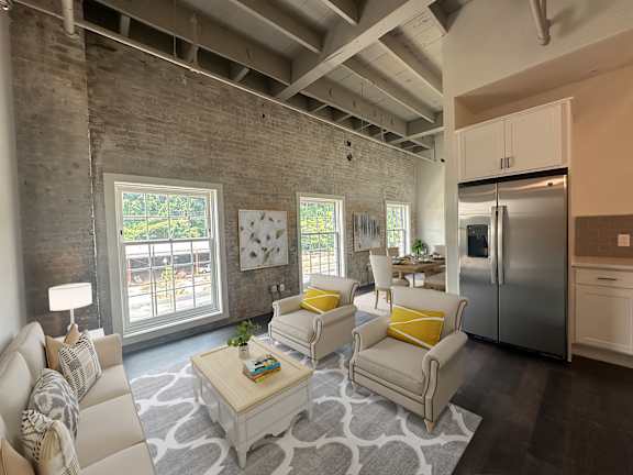 A modern living room with a white sofa, yellow pillows, and a coffee table.