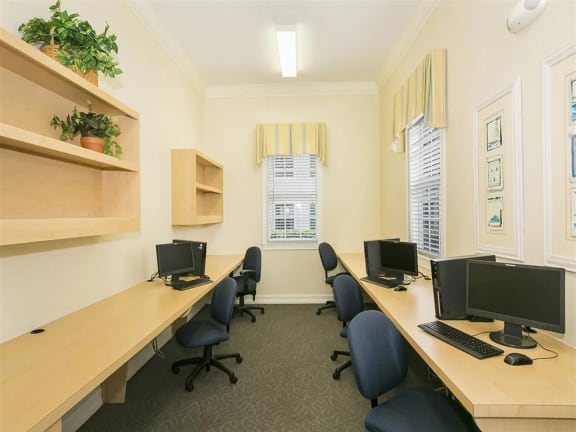 a room with three desks and three computer monitors