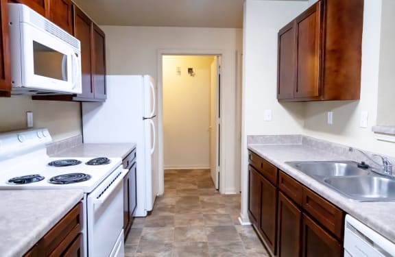 a kitchen with white appliances and wooden cabinets