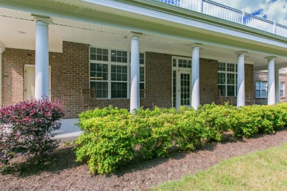 a building with four pillars and a garden in front of it