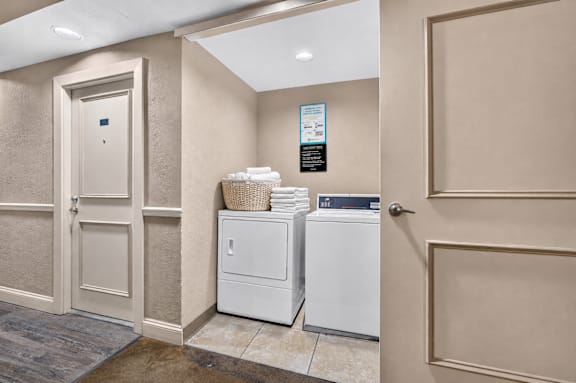 A laundry room with a washer and dryer stacked on top of each other.
