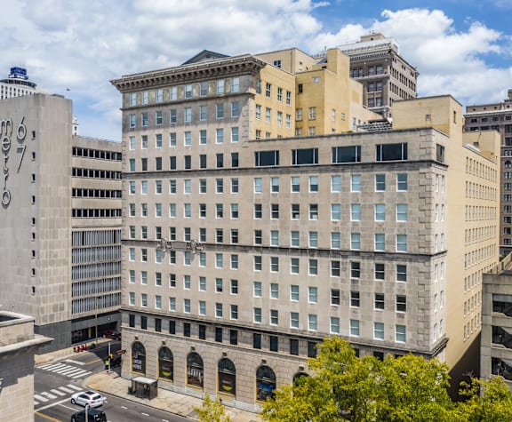 A large, multi-story building with a flat roof and a row of arched windows on the ground floor.