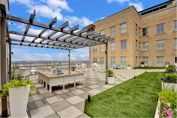 A patio with a table and chairs under a pergola.