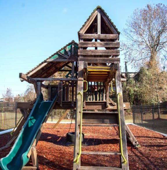 a playset with a slide and stairs in a park