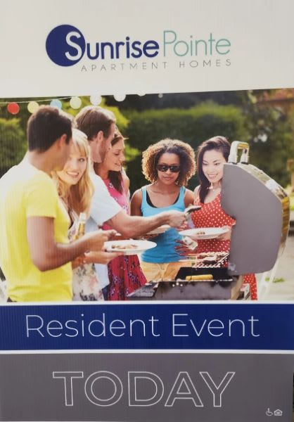a group of people standing around a grill