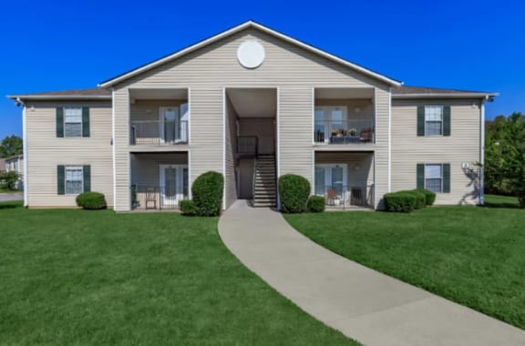 an apartment building with a sidewalk in front of it