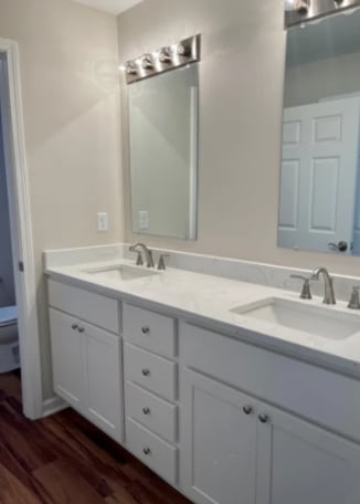 a white bathroom with two sinks and a mirror