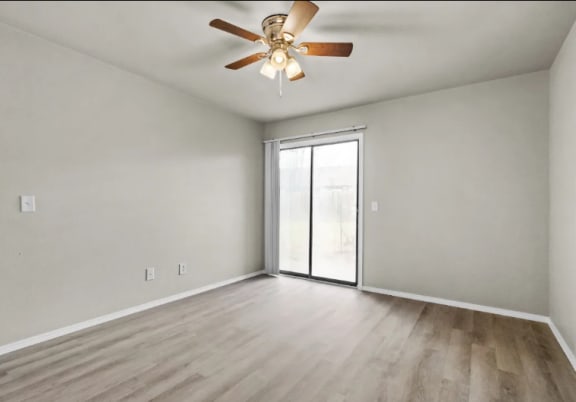 an empty living room with a ceiling fan and a sliding glass door at Osage Creek, Rogers, AR, 72756