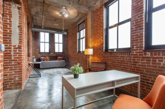 a living room with exposed brick walls and a white table