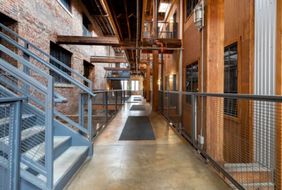 the interior of a building with stairs and metal fences