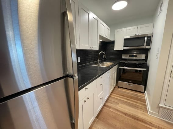 a kitchen with stainless steel appliances and white cabinets at The Courts Midtown, Memphis, TN, 38104