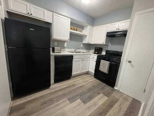 a kitchen with black appliances and white cabinets at The Junction, Tennessee, 38111