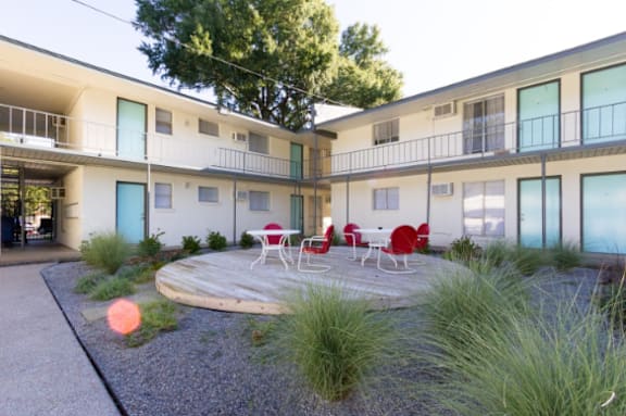 an outside courtyard with tables and chairs in an apartment building at The Junction, Memphis, TN, 38111