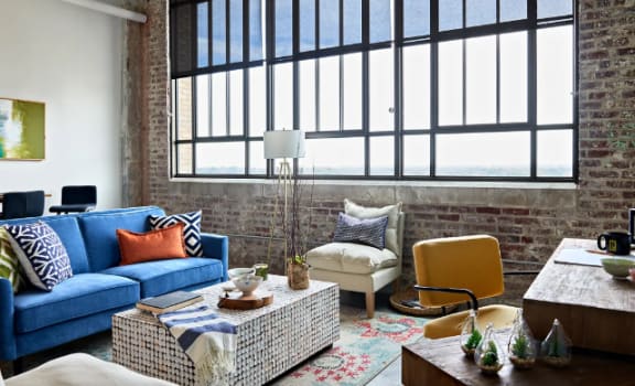 a living room with a blue couch and a large window at Parcels at Concourse, Memphis, 38104
