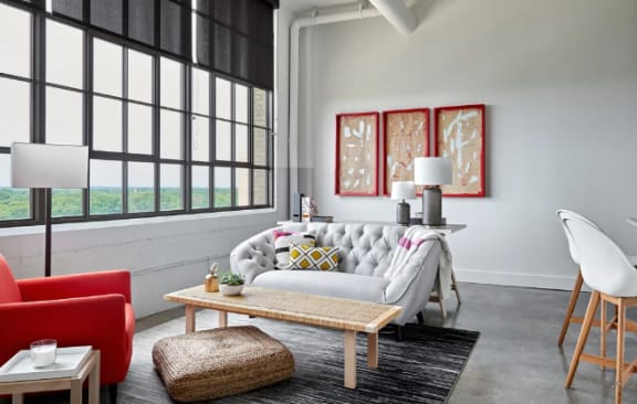 a living room with a couch and a table in front of a window at Parcels at Concourse, Memphis
