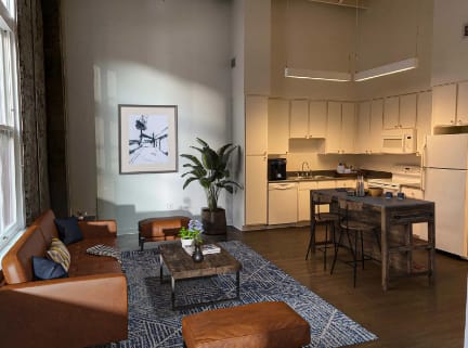 a living room with couches and a table and a kitchen at Lofts at Union Alley, Tennessee, 38103
