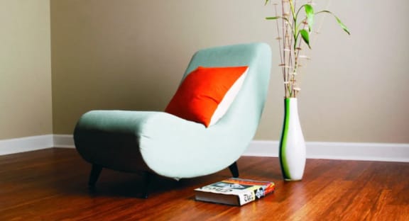 a chair with a orange pillow and a vase with flowers at Metro67, Memphis, 38103