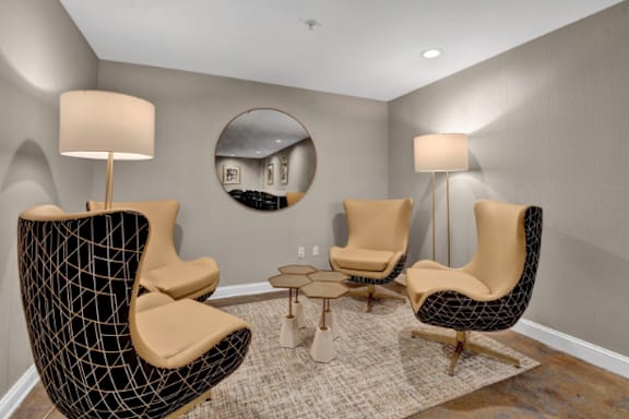 a living room with chairs and lamps and a mirror at Metro67, Memphis