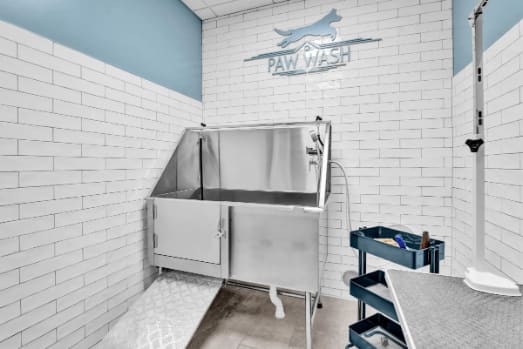 a white tiled bathroom with a stainless steel sink and a fish tank  at Metro67, Memphis, TN