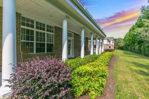 a house with a lawn and bushes in front of it