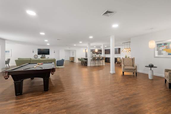 A spacious room with a pool table and comfortable seating.