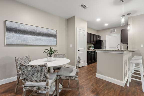 A modern kitchen with a dining table and chairs.