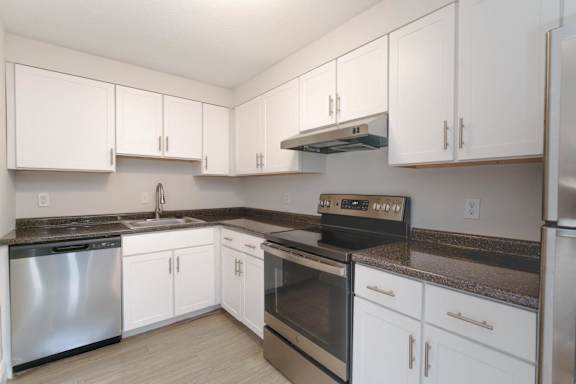 a kitchen with white cabinets and stainless steel appliances