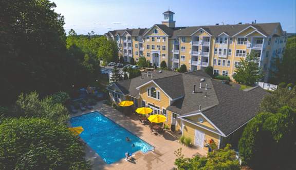 A large building with a pool in front of it.