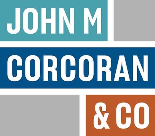 A blue and orange sign with the words "John M Corcoran & Co" on it.