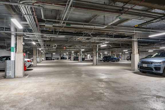 A spacious parking garage with multiple cars parked.