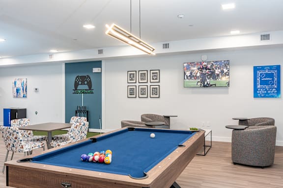 A pool table with a blue cloth and several balls on it.