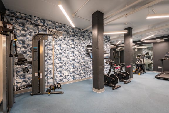 a gym with blue and white wallpaper and exercise equipment