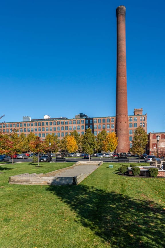 a view of a park with a smokestack and a building