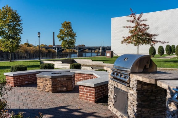 a patio with a barbecue grill and benches