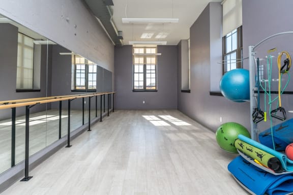 a fitness room with yoga equipment and mirrors at the 240 building