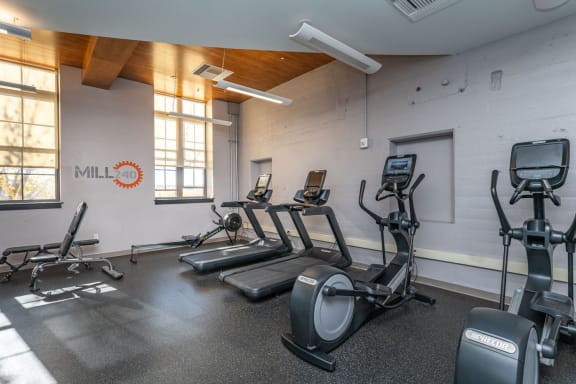 a gym with treadmills, bench, ellipitcals,  and other exercise equipment