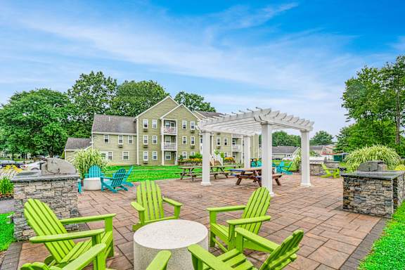 an outdoor patio with chairs and a pergola at Station Pointe, Mansfield, 02048