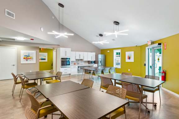 a dining room with tables and chairs and a kitchen at Station Pointe, Mansfield, 02048