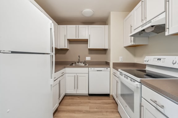 an empty kitchen with white appliances and white cabinets at Chapman House, E. Boston