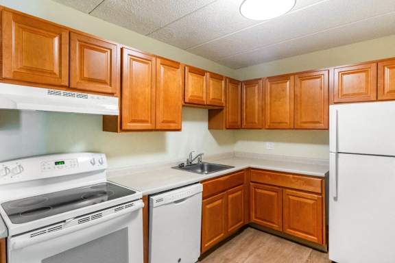 A kitchen with white appliances and wooden cabinets	at Edmands House, Framingham, 01701