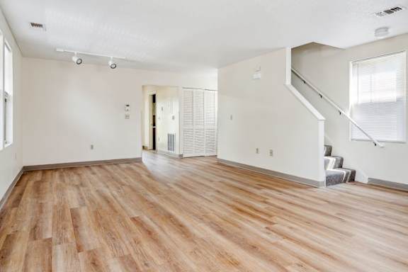 an empty living room with a hard wood floor and white walls at Monterey Place, New Haven, 06511