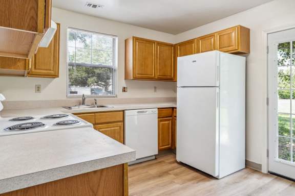A kitchen with white appliances and wooden cabinets at Monterey Place, New Haven, 06511