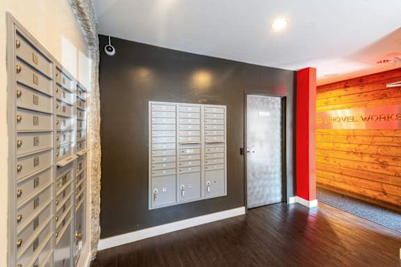 a hallway with a door to a wine room and a wall with a wooden wall at Ames Shovel Works Apartments, Massachusetts, 02356