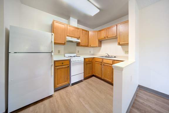 A kitchen with wooden cabinets and a white refrigerator.