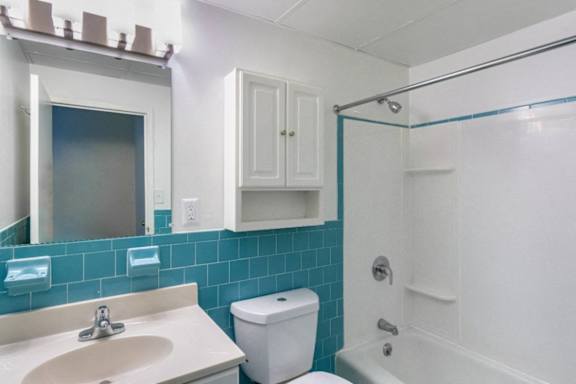 A white toilet sits next to a sink in a bathroom	at Edmands House, Framingham, 01701