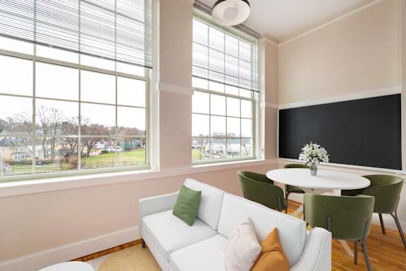 a living room with a white couch and a table with chairs at Beverly Village for Living & the Arts Apartments, Beverly, 01915