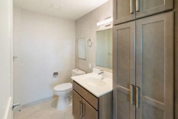 A bathroom with a toilet, sink, and mirror at Pok Oi Residences, Boston, MA, Massachusetts, 2111